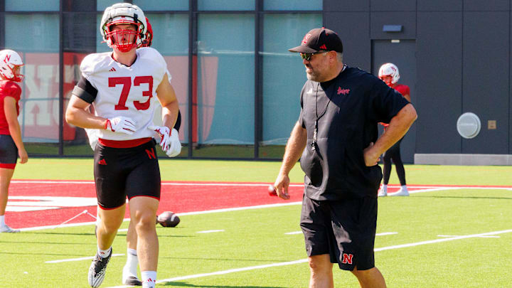 Nebraska head coach Matt Rhule looks over a linemen drill while offensive lineman Kade Pietrzak runs to the next station.