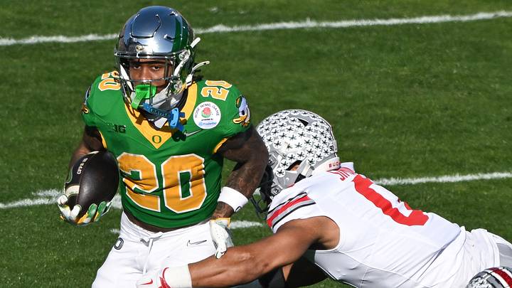 Jan 1, 2025; Pasadena, CA, USA; Ohio State Buckeyes linebacker Cody Simon (0) tackles Oregon Ducks running back Jordan James (20) during the first quarter at Rose Bowl Stadium. Mandatory Credit: Robert Hanashiro-Imagn Images