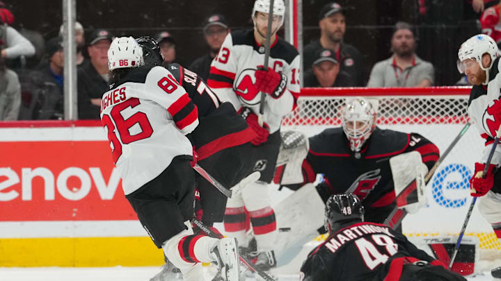 Mar 28, 2026; Raleigh, North Carolina, USA;  New Jersey Devils center Jack Hughes (86) gets the shot away against the Carolina Hurricanes during the third period at Lenovo Center. Mandatory Credit: James Guillory-Imagn Images
