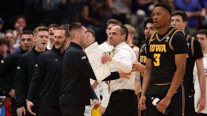 Mar 22, 2026; Tampa, FL, USA; Iowa Hawkeyes head coach Ben McCollum is held back after a fight against the Florida Gators in the first half during a second round game of the men's 2026 NCAA Tournament at Benchmark International Arena. Mandatory Credit: Matt Pendleton-Imagn Images