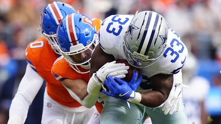 Oct 26, 2025; Denver, Colorado, USA; Denver Broncos linebacker Justin Strnad (40) tackles Dallas Cowboys running back Javonte Williams (33) in the first quarter at Empower Field at Mile High. 