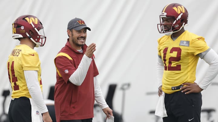 Jun 8, 2023; Ashburn, Virginia, USA; Washington Commanders quarterbacks coach Tavita Pritchard (M) talks to Commanders quarterback Sam Howell (14) and Commanders quarterback Jacoby Brissett (12) during day three of minicamp at OrthoVirginia Training Center at Commanders Park, held inside the training bubble due to poor air quality from Canadian wildfire smoke in Ashburn. Mandatory Credit: Geoff Burke-Imagn Images