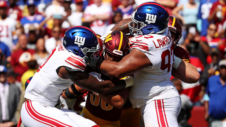 Sep 15, 2024; Landover, Maryland, USA; Washington Commanders running back Austin Ekeler (30) is tackled by New York Giants defensive tackle Dexter Lawrence II (97) during the fourth quarter at Commanders Field. Mandatory Credit: Peter Casey-Imagn Images