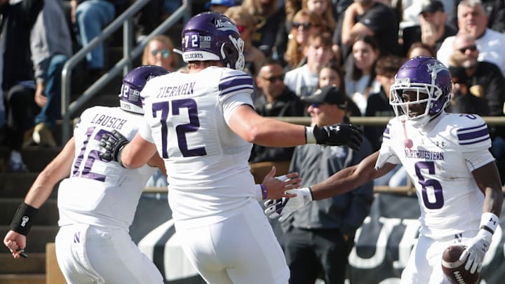Northwestern Wildcats running back Joseph Himon II (6) celebrates with Northwestern Wildcats quarterback Jack Lausch (12) and Northwestern Wildcats offensive lineman Caleb Tiernan (72) after scoring Saturday, Nov. 2, 2024, during the NCAA football game against the Purdue Boilermakers at Ross-Ade Stadium in West Lafayette, Ind. Northwestern Wildcats running back Joseph Himon II (6) celebrates with Northwestern Wildcats quarterback Jack Lausch (12) and Northwestern Wildcats offensive lineman Caleb Tiernan (72) after scoring Saturday, Nov. 2, 2024, during the NCAA football game against the Purdue Boilermakers at Ross-Ade Stadium in West Lafayette, Ind.