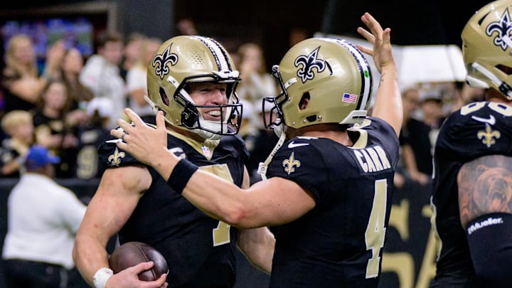Nov 17, 2024; New Orleans, Louisiana, USA; New Orleans Saints tight end Taysom Hill (7) celebrates a touchdown during the fourth quarter against the Cleveland Browns with New Orleans Saints quarterback Derek Carr (4) at Caesars Superdome. Mandatory Credit: Matthew Hinton-Imagn Images