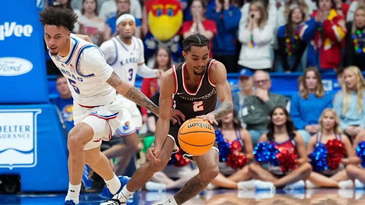 Dec 22, 2024; Lawrence, Kansas, USA; Kansas Jayhawks guard Zeke Mayo (5) and Brown Bears guard Jeremiah Jenkins (2) fight for a loose ball during the second half at Allen Fieldhouse. Mandatory Credit: Denny Medley-Imagn Images