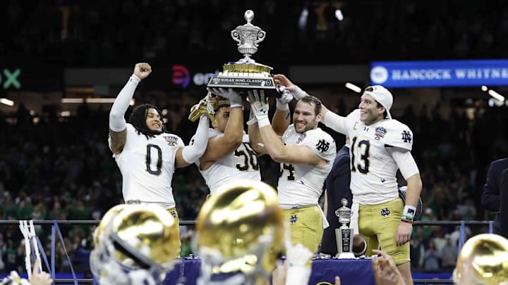 Notre Dame safety Xavier Watts, defensive lineman Howard Cross III, linebacker Jack Kiser and quarterback Riley Leonard celebrate with the Sugar Bowl trophy.