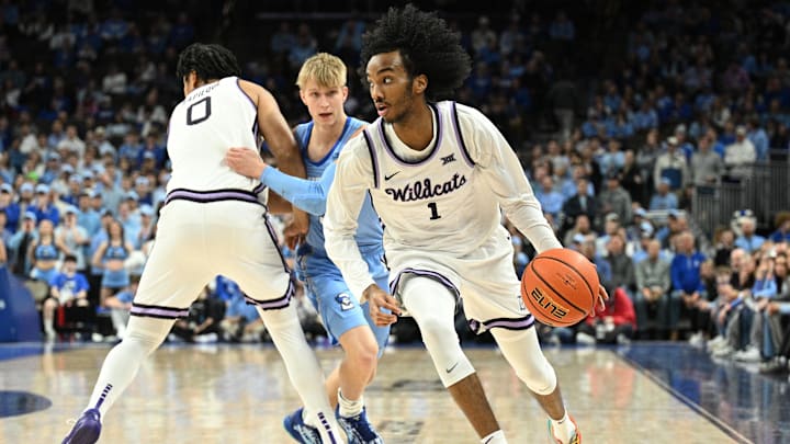 Dec 13, 2025; Omaha, Nebraska, USA;  Kansas State Wildcats guard Abdi Bashir Jr. (1) drives around Creighton Bluejays guard Ty Davis (9) during the first half at CHI Health Center Omaha. Mandatory Credit: Steven Branscombe-Imagn Images