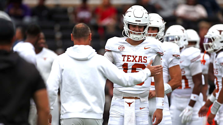 Texas Longhorns quarterback Arch Manning runs the ball with head coach Steve Sarkisian during warm ups prior to the game against the Mississippi State Bulldogs at Davis Wade Stadium at Scott Field.