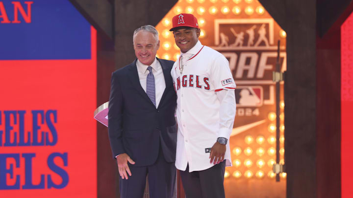 Jul 14, 2024; Ft. Worth, TX, USA;  Christian Moore is congratulated by MLB commissioner Rob Manfred after being selected by the Los Angeles Angels as the eight player taken during the first round of the MLB Draft at Cowtown Coliseum. Mandatory Credit: Kevin Jairaj-USA TODAY Sports