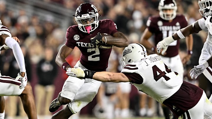 Nov 11, 2023; College Station, Texas, USA; Texas A&M Aggies running back Rueben Owens (2) runs the ball during the second half as Mississippi State Bulldogs linebacker Jett Johnson (44) defends at Kyle Field. Mandatory Credit: Maria Lysaker-Imagn Images
