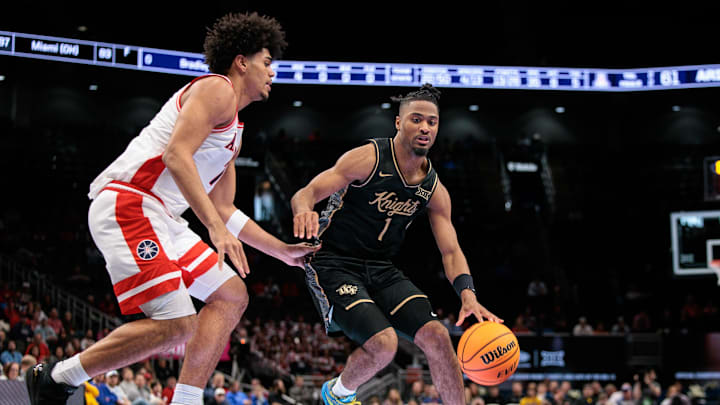 Mar 12, 2026; Kansas City, MO, USA; UCF Knights guard Themus Fulks (1) drives around Arizona Wildcats guard Jackson Francois (7) during the second half at T-Mobile Center. Mandatory Credit: William Purnell-Imagn Images