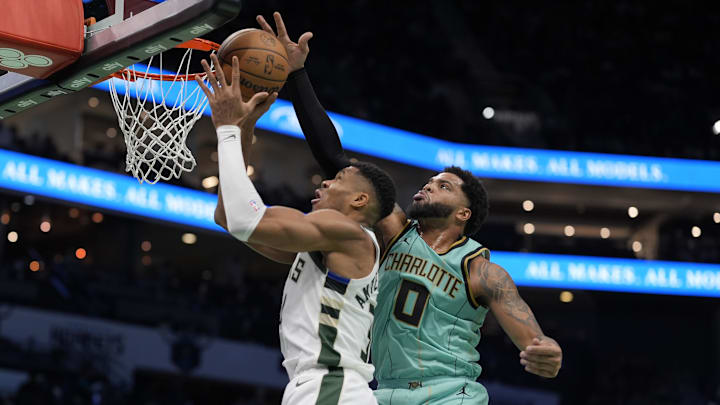 Nov 16, 2024; Charlotte, North Carolina, USA; Charlotte Hornets forward Miles Bridges (0) blocks a shot by Milwaukee Bucks forward Giannis Antetokounmpo (34) during the second quarter at Spectrum Center. Mandatory Credit: Jim Dedmon-Imagn Images