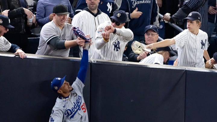 Mookie Betts makes a catch and is interfered with by a pair of New York Yankees fans at Yankee Stadium.