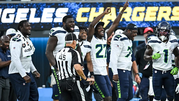 Aug 10, 2024; Inglewood, California, USA; Seattle Seahawks cornerback Riq Woolen (27) and other teammates react from the sidelines after a play against the Los Angeles Chargers during the fourth quarter at SoFi Stadium. 