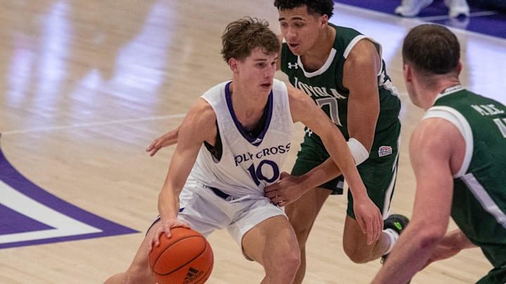 Holy Cross freshman Max Green moves past Loyola’s Braeden Speed at the Hart Center.