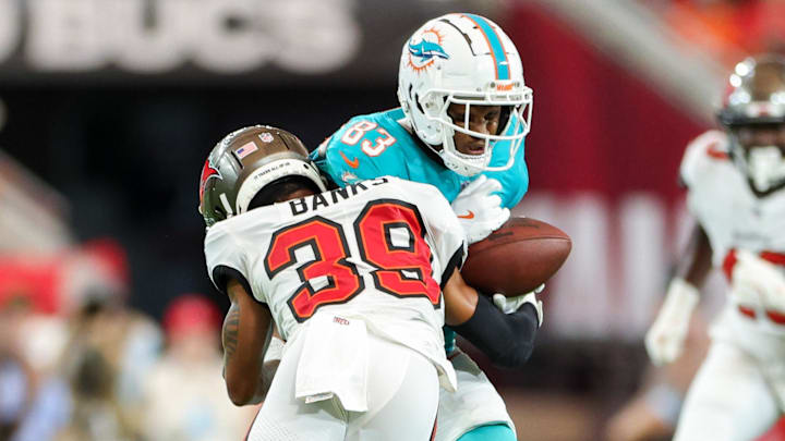 Aug 23, 2024; Tampa, Florida, USA; Tampa Bay Buccaneers safety Marcus Banks (39) hits Miami Dolphins wide receiver Malik Washington (83) in the first quarter during preseason at Raymond James Stadium.