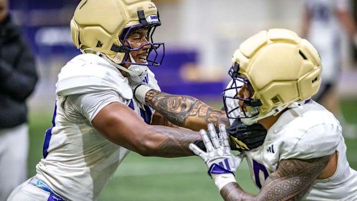 Linebackers Zaydrius Rainey-Sale and Jacob Manu tangle in a spring drill in Dempsey Indoor.