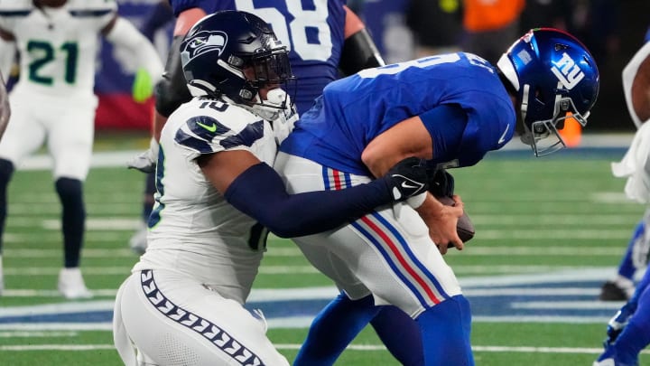Oct 2, 2023; East Rutherford, New Jersey, USA; New York Giants quarterback Daniel Jones (8) is sacked by Seattle Seahawks linebacker Uchenna Nwosu (10) in the second half at MetLife Stadium. Mandatory Credit: Robert Deutsch-USA TODAY Sports