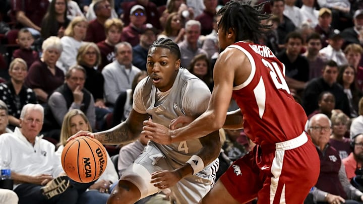 Feb 15, 2025; College Station, Texas, USA; Texas A&M Aggies guard Wade Taylor IV (4) drives as Arkansas Razorbacks guard D.J. Wagner (21) defends during the first half at Reed Arena. Mandatory Credit: Maria Lysaker-Imagn Images 