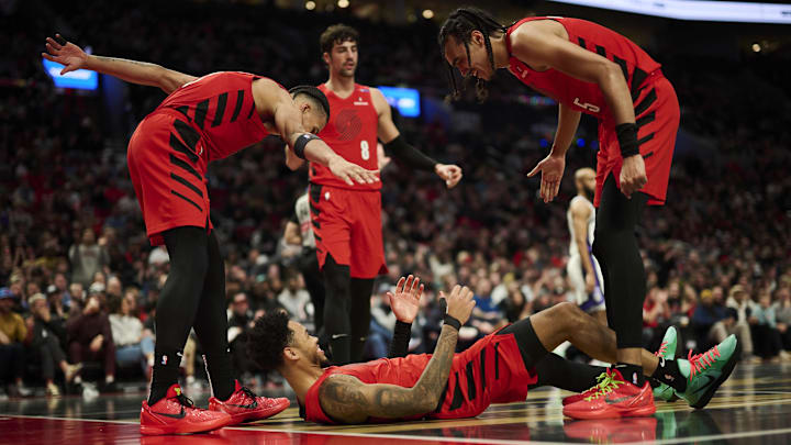 Nov 29, 2024; Portland, Oregon, USA; Portland Trail Blazers guard Anfernee Simons (1) reacts with teammates forward Toumani Camara (33), left, and guard Dalano Banton (5) during the first half against the Sacramento Kings at Moda Center. Mandatory Credit: Troy Wayrynen-Imagn Images