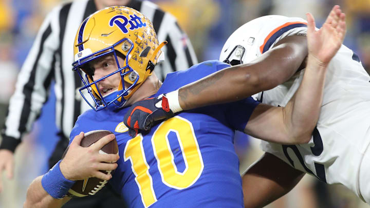 Nov 9, 2024; Pittsburgh, Pennsylvania, USA;  Pittsburgh Panthers quarterback Eli Holstein (10) is tackled by Virginia Cavaliers defensive tackle Terrell Jones (25) during the second quarter at Acrisure Stadium. Mandatory Credit: Charles LeClaire-Imagn Images
