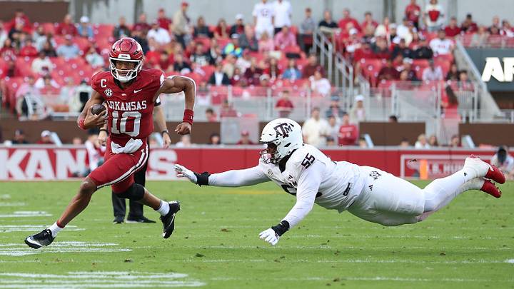 Arkansas Razorbacks quarterback Taylen Green (10) rushes in the second quarter as Texas A&M Aggies defensive tackle Dealyn Evans (55) attempts a tackle at Donald W. Reynolds Razorback Stadium. 