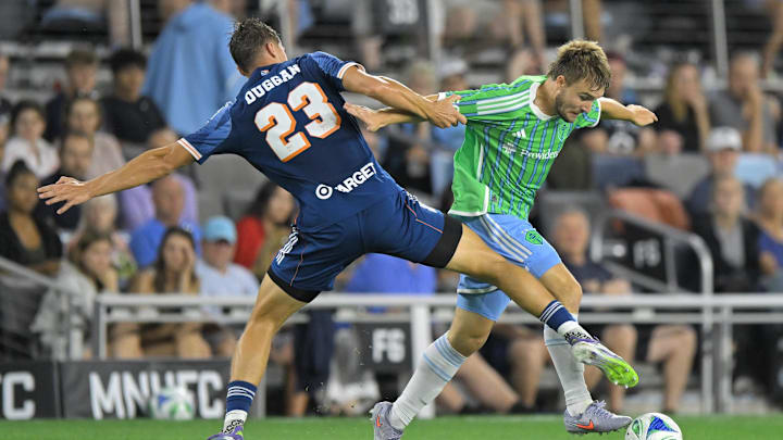 Aug 16, 2025; Saint Paul, Minnesota, USA;  Minnesota United defender Morris Duggan (23) strips Seattle Sounders forward Pedro de la Vega (10) of the ball during the second half at Allianz Field. Mandatory Credit: Nick Wosika-Imagn Images