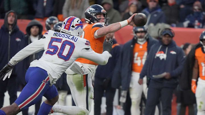 Denver Broncos quarterback Bo Nix chucks the ball for an incompletion as Buffalo Bills defensive end Greg Rousseau bares down on him during second half action at Empower FIeld at Mile High in Denver, Colorado on Jan. 17, 2026.