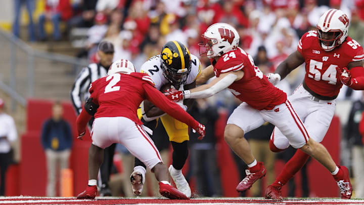 Oct 14, 2023; Madison, Wisconsin, USA;  Iowa Hawkeyes running back Kaleb Johnson (2) is tackled by Wisconsin Badgers cornerback Ricardo Hallman (2) and safety Hunter Wohler (24) during the first quarter at Camp Randall Stadium. Mandatory Credit: Jeff Hanisch-Imagn Images