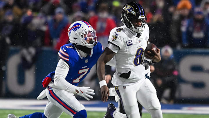 Jan 19, 2025; Orchard Park, New York, USA; Baltimore Ravens quarterback Lamar Jackson (8) tries to outrun Buffalo Bills cornerback Taron Johnson (7) in the first quarter of a 2025 AFC divisional round game 