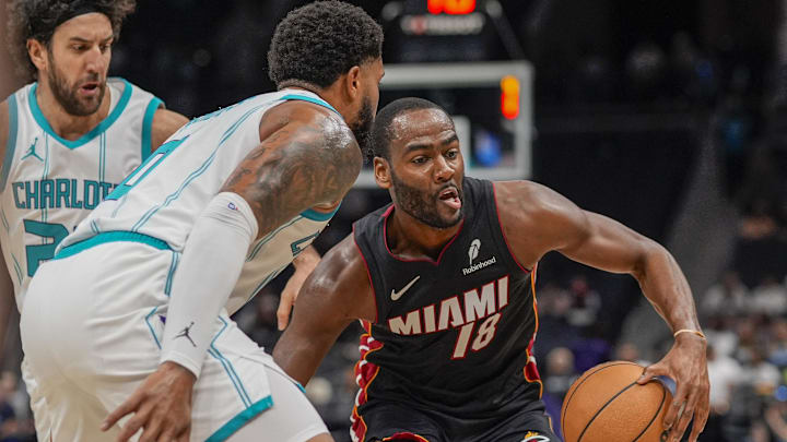 Oct 8, 2024; Charlotte, North Carolina, USA; Miami Heat guard Alec Burks (18) handles the ball while defended by Charlotte Hornets forward Miles Bridges (0) during the first quarter at Spectrum Center. Mandatory Credit: Jim Dedmon-Imagn Images