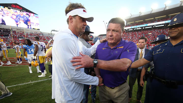 Oct 23, 2021; Oxford, Mississippi, USA; Mississippi Rebels head coach Lane Kiffin (left) and LSU Tigers head coach Ed Orgeron (right) shake hands after a game at Vaught-Hemingway Stadium. Mandatory Credit: Petre Thomas-Imagn Images