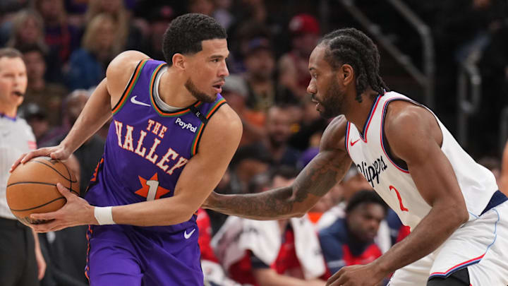 Mar 4, 2025; Phoenix, Arizona, USA; LA Clippers forward Kawhi Leonard (2) guards Phoenix Suns guard Devin Booker (1) during the first half at PHX Center. Mandatory Credit: Joe Camporeale-Imagn Images