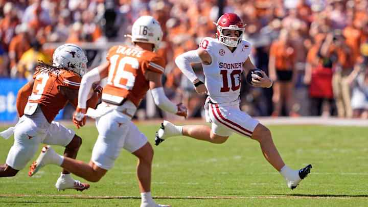 Oklahoma Sooners quarterback John Mateer (10) rushes as Texas Longhorns defensive back Jaylon Guilbeau (3) and Texas Longhorns defensive back Michael Taaffe (16) defend in the first half of the Red River Rivalry college football game between the University of Oklahoma Sooners and the Texas Longhorn at the Cotton Bowl Stadium in Dallas, Texas, Saturday, Oct. 11, 2025.