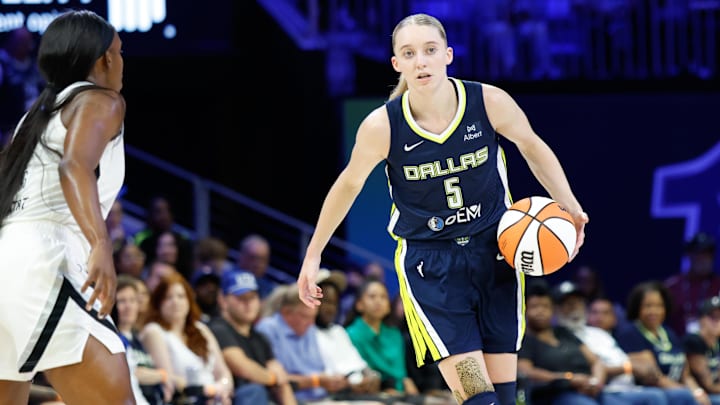 Jul 16, 2025; Arlington, Texas, USA; Dallas Wings guard Paige Bueckers (5) controls the ball against Las Vegas Aces guard Jackie Young (0) during the second half at College Park Center. Mandatory Credit: Chris Jones-Imagn Images