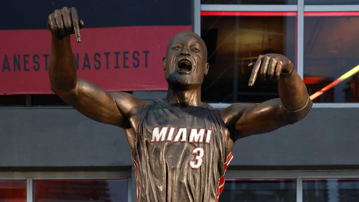 Oct 28, 2024; Miami, Florida, USA;  Former Miami Heat guard Dwyane Wade poses with his statue in front of the Kaseya Center. Mandatory Credit: Rhona Wise-Imagn Images