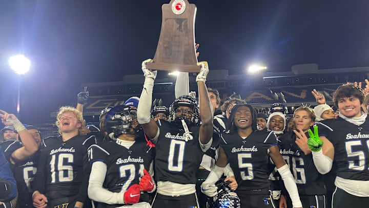 Stephen Decatur's Davin Coleman hoists the MPSSAA Class 2A state championship trophy as his teammates celebrate their second straight title, following Saturday's 13-12 win over Huntingtown. Stephen Decatur's Davin Coleman hoists the MPSSAA Class 2A state championship trophy as his teammates celebrate their second straight title, following Saturday's 13-12 win over Huntingtown.