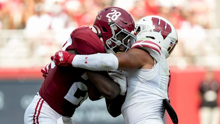 Sep 13, 2025; Tuscaloosa, Alabama, USA;  Alabama running back Kevin Riley (28) is tackled by Wisconsin defensive back Geimere Latimer II (1) at Saban Field at Bryant-Denny Stadium. Mandatory Credit: Gary Cosby-USA TODAY Network via Imagn Images