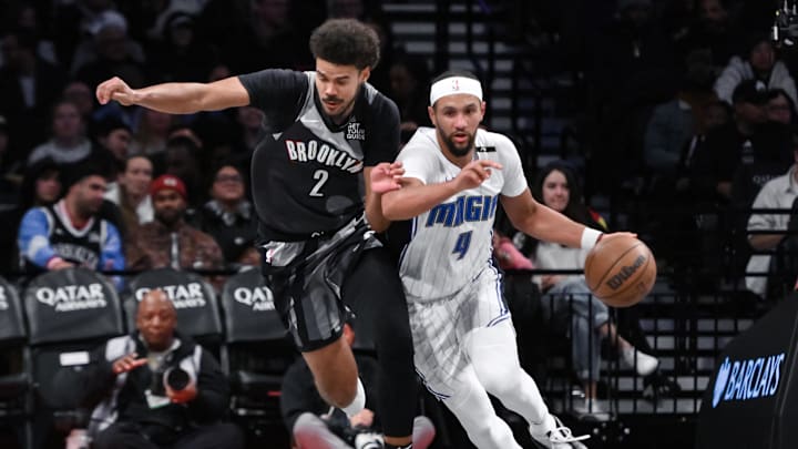 Dec 1, 2024; Brooklyn, New York, USA; Orlando Magic guard Jalen Suggs (4) brings the ball up court while being defended by Brooklyn Nets forward Cameron Johnson (2) during the first half at Barclays Center. Mandatory Credit: John Jones-Imagn Images