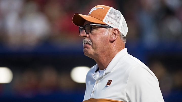 Texas Longhorns head coach Mike White walks out to the coaches box in the sixth inning against the Texas Tech Red Raiders during game one of the NCAA Softball Women's College World Series finals at Devon Park. 
