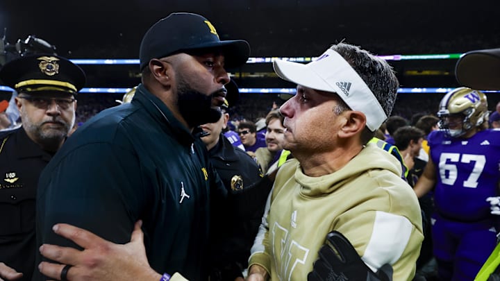Oct 5, 2024; Seattle, Washington, USA; Michigan Wolverines head coach Sherrone Moore, left, shakes hands with Washington Huskies head coach Jedd Fisch, right, following a Washington victory at Alaska Airlines Field at Husky Stadium. Oct 5, 2024; Seattle, Washington, USA; Michigan Wolverines head coach Sherrone Moore, left, shakes hands with Washington Huskies head coach Jedd Fisch, right, following a Washington victory at Alaska Airlines Field at Husky Stadium.