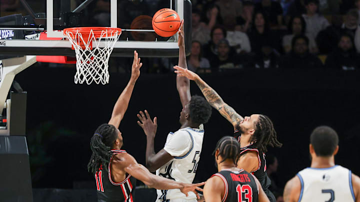 Jan 18, 2025; Orlando, Florida, USA; UCF Knights center Moustapha Thiam (52) goes to the basket against Houston Cougars forward Joseph Tugler (11) during the second half at Addition Financial Arena. Mandatory Credit: Mike Watters-Imagn Images