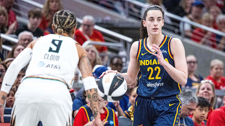 Jun 14, 2025; Indianapolis, Indiana, USA; Indiana Fever guard Caitlin Clark (22) dribbles the ball while New York Liberty guard Natasha Cloud (9) defends in the first half at Gainbridge Fieldhouse. Mandatory Credit: Trevor Ruszkowski-Imagn Images