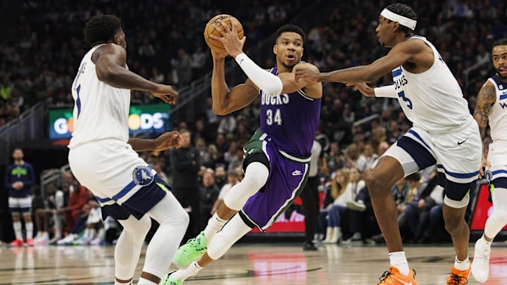 Dec 30, 2022; Milwaukee, Wisconsin, USA;  Milwaukee Bucks forward Giannis Antetokounmpo (34) drives for the basket between Minnesota Timberwolves guard Anthony Edwards (1) and forward Jaden McDaniels (3) during the second quarter at Fiserv Forum. Mandatory Credit: Jeff Hanisch-Imagn Images