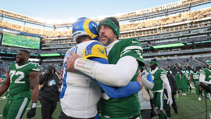 Dec 22, 2024; East Rutherford, New Jersey, USA;  Los Angeles Rams quarterback Matthew Stafford (9) hits New York Jets quarterback Aaron Rodgers (8) after the game at MetLife Stadium. Mandatory Credit: Vincent Carchietta-Imagn Images