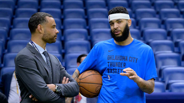 Mar 26, 2024; New Orleans, Louisiana, USA; Trajan Langdon, the general manager of the New Orleans Pelicans, left, talks with  Oklahoma City Thunder forward Kenrich Williams (34) before a game at Smoothie King Center. Mandatory Credit: Matthew Hinton-Imagn Images