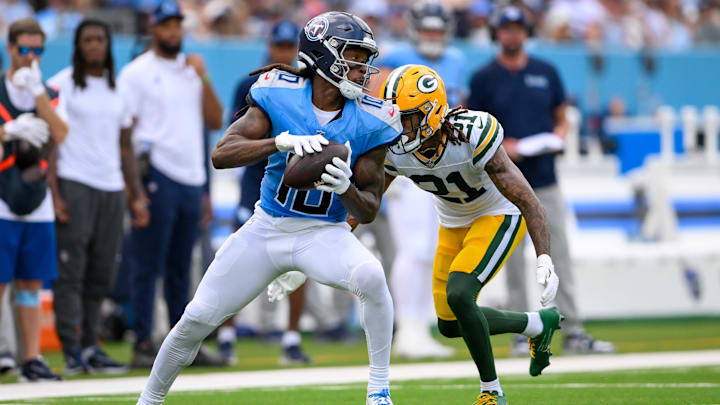 Sep 22, 2024; Nashville, Tennessee, USA;  Tennessee Titans wide receiver DeAndre Hopkins (10) makes a catch as Green Bay Packers cornerback Eric Stokes (21) converses during the first half at Nissan Stadium. Mandatory Credit: Steve Roberts-Imagn Images