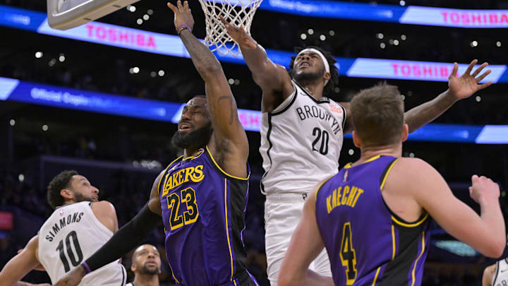 Jan 17, 2025; Los Angeles, California, USA;  Brooklyn Nets guard Ben Simmons (10) and center Day'Ron Sharpe (20) blocks a shot by Los Angeles Lakers forward LeBron James (23) in the second half at Crypto.com Arena. Mandatory Credit: Jayne Kamin-Oncea-Imagn Images