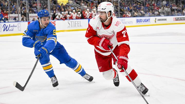 Oct 28, 2025; St. Louis, Missouri, USA; Detroit Red Wings center Dylan Larkin (71) controls the puck as St. Louis Blues left wing Alexandre Texier (9) defends during the third period at Enterprise Center. Mandatory Credit: Jeff Curry-Imagn Images